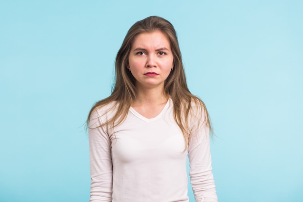 Photo portrait of sad woman standing on blue background