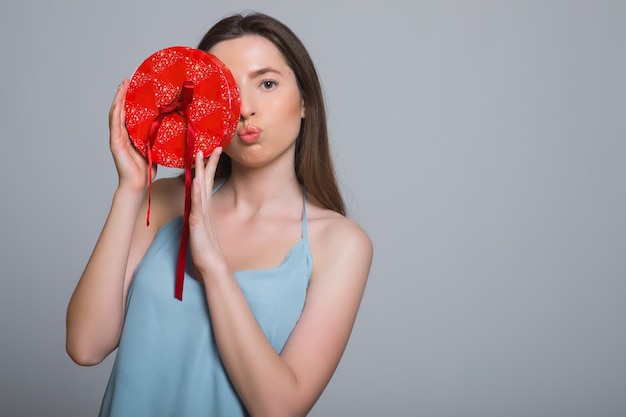 Portrait of a sad woman standing with opened gift box isolated on a white