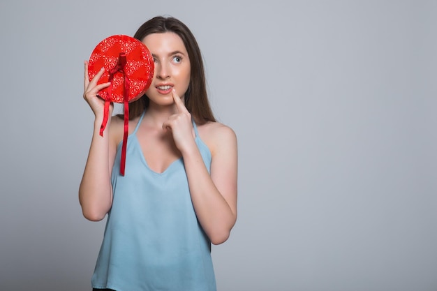 Portrait of a sad woman standing with opened gift box isolated on a white