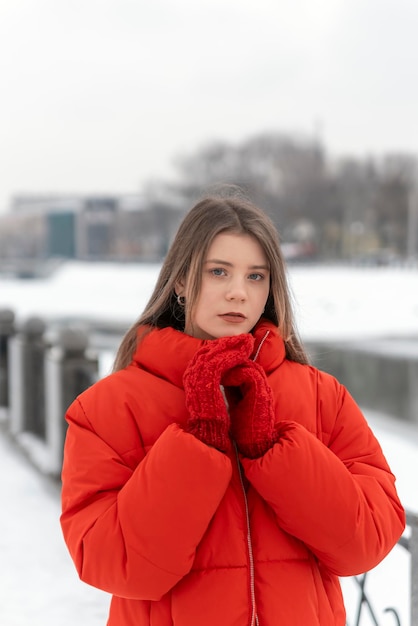 Portrait of sadness cute girl with light makeup in red jacket in winter outside Warm clothing for walking