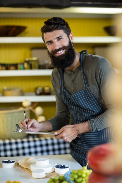 Foto ritratto di venditore scrivere negli appunti al bancone