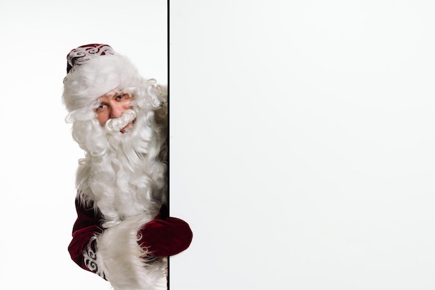 Foto ritratto di babbo natale mostrando cartellone ritratto di babbo natale sorridente su sfondo bianco