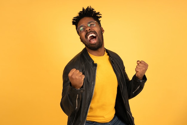 Portrait of a satisfied man celebrating success while standing against isolated background