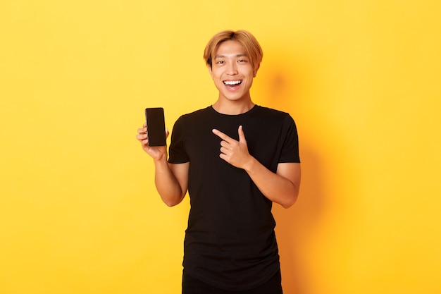 Portrait of satisfied smiling asian guy with blond hair