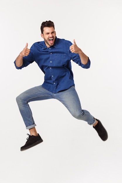 Portrait of a satisfied young caucasian man celebrating success isolated over white .