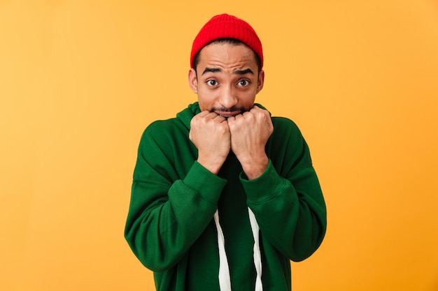 Portrait of a scared young afro american man in hat