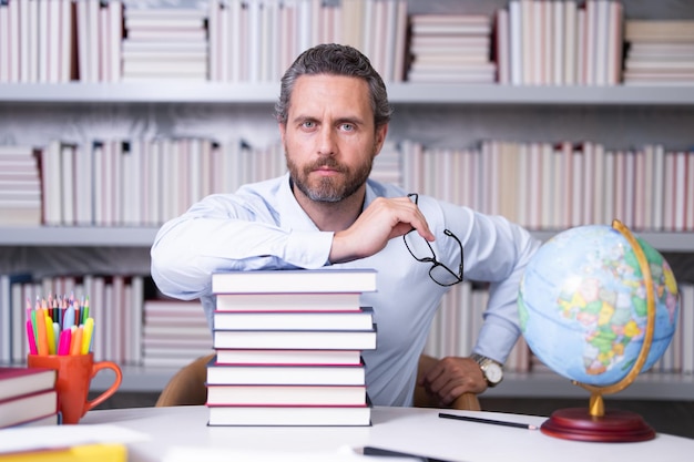 Portrait of school teacher with book in classroom handsome teacher in classroom teachers day good sc