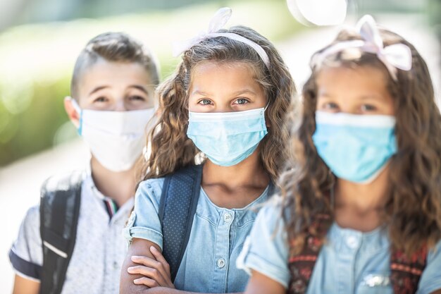 Foto ritratto di scolari con maschere facciali durante la quarantena covid-19.