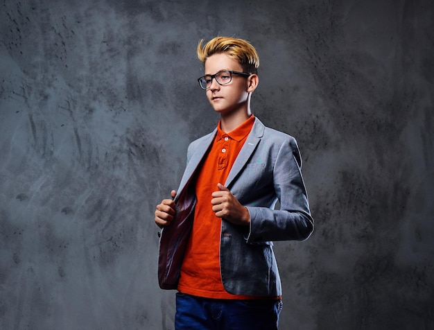 Portrait of schooler teenage boy in eyeglasses dressed in a stylish jacket.