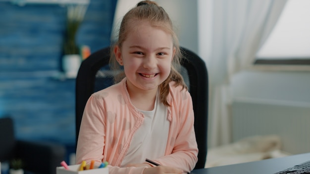 Portrait of schoolgirl using notebook and pen to write homework