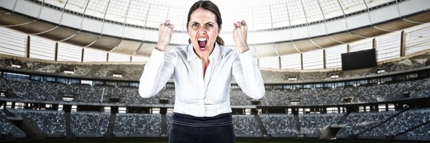 Foto ritratto di donna d'affari urlante che sbatte i pugni contro il palo della porta di rugby in una giornata di sole nello stadio