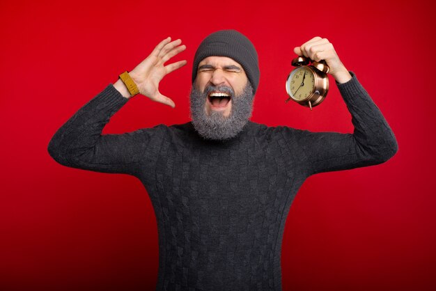 Photo portrait of screaming man holding alarm clock