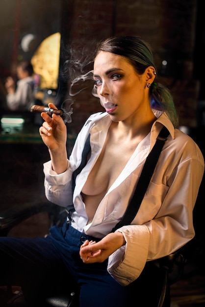 Foto ritratto di una donna seducente che fuma un sigaro a casa