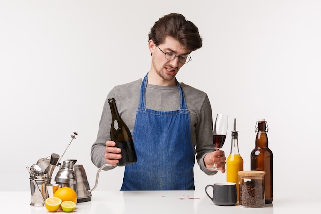 Portrait of self-assured friendly young caucasian man in apron