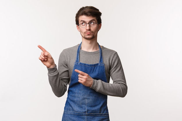 Portrait of self-assured friendly young caucasian man in apron