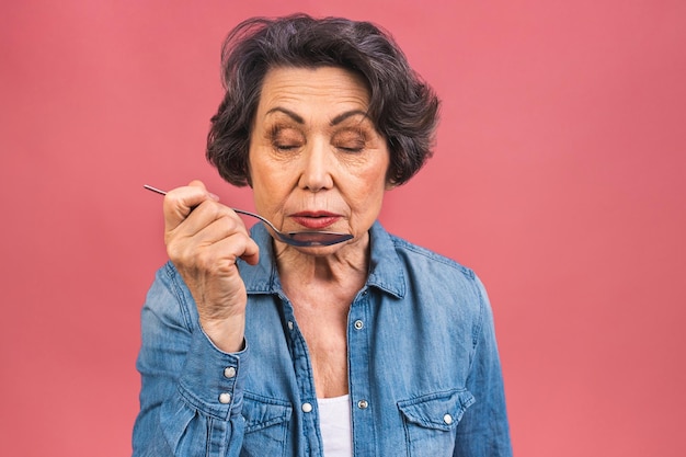 Photo portrait of senior aged mature woman holding spoon calculating calories meal