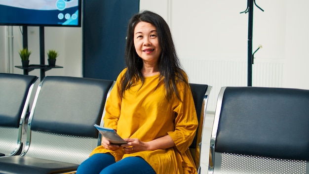 Portrait of senior asian woman in hospital waiting room having checkup appointment with physician. Attending medical consultation with specialist to cure disease and get treatment.