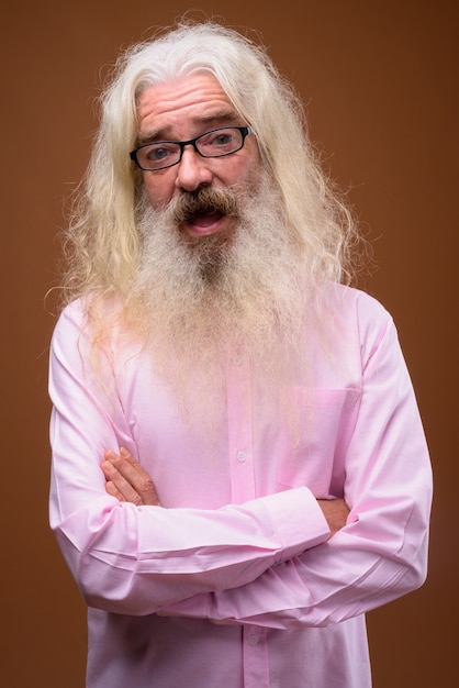 Портрет старшего бородатого мужчины в розовой рубашке и улыбающегося