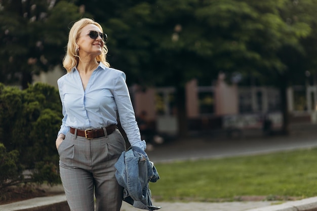 Portrait senior business professional walking outside Mature business woman walking outdoors on street Success