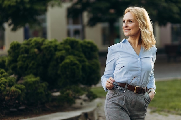 Portrait senior business professional walking outside Mature business woman walking outdoors on street Success