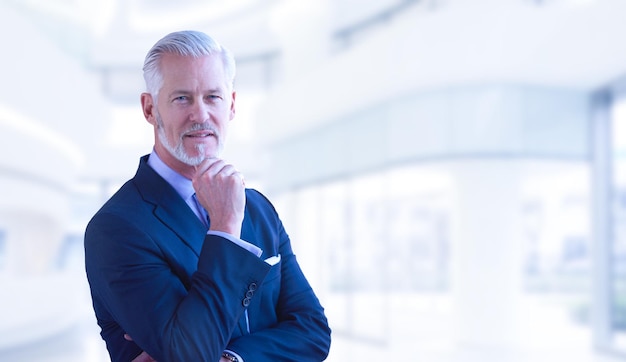 Portrait of senior businessman in front of his modern office