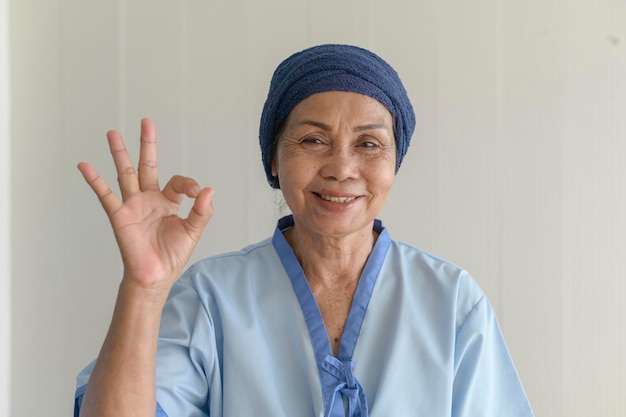 Portrait of senior cancer patient woman wearing head scarf in hospital healthcare and medical concept