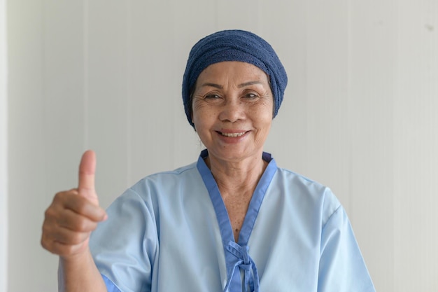 Portrait of senior cancer patient woman wearing head scarf in hospital