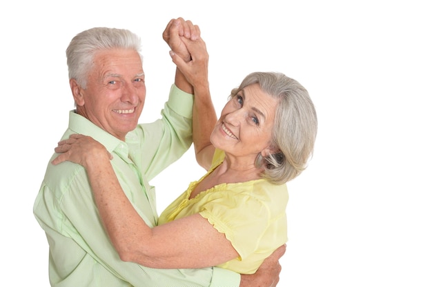 Portrait of senior couple dancing on white background