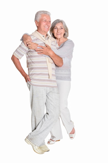 Portrait of senior couple hugging on white background full length