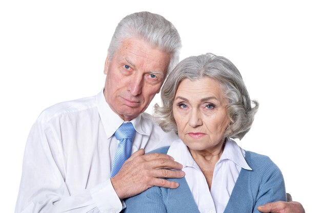 Portrait of senior couple hugging on white background