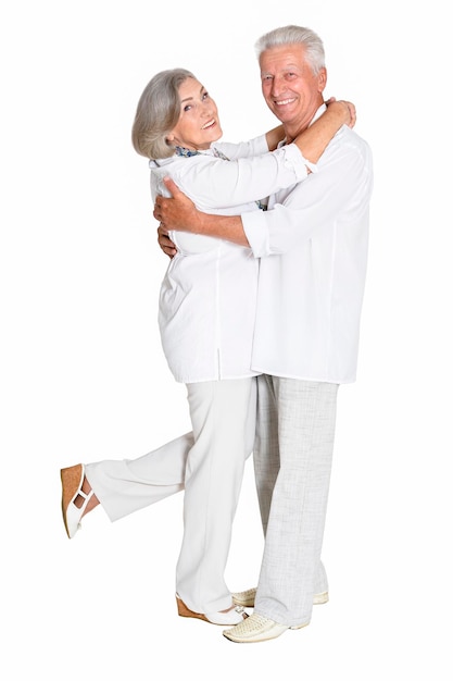 Portrait of senior couple hugging on white background