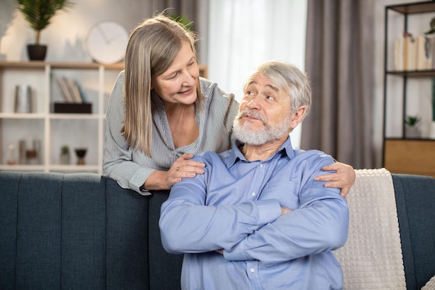 Portrait of senior couple posing together in living room