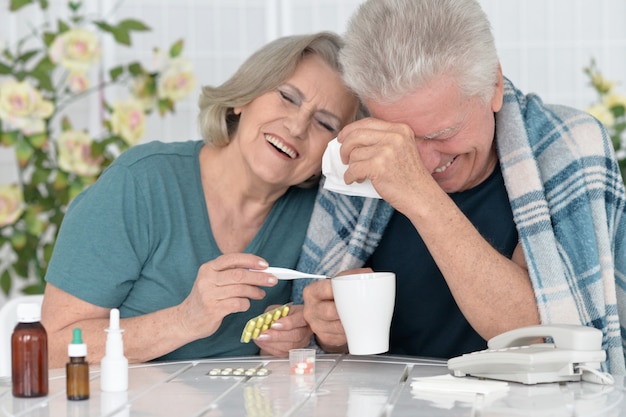 portrait of  senior couple with pills at home