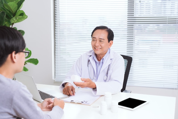 portrait of senior doctor sitting at his desk in medical office