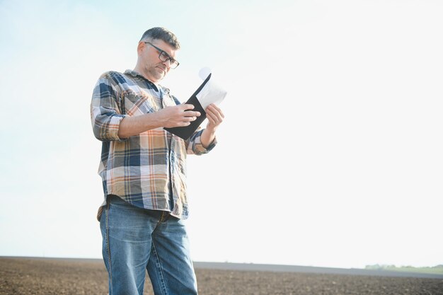 Portrait of senior farmer with glasses in field