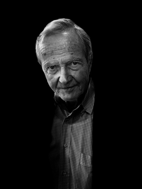 portrait of senior man against black background