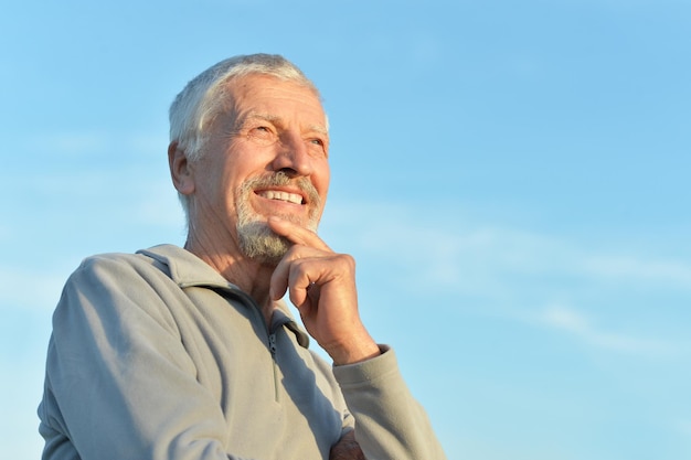 Portrait of senior man against blue sky