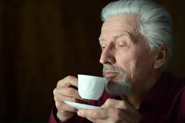 Portrait of senior man drinking at home