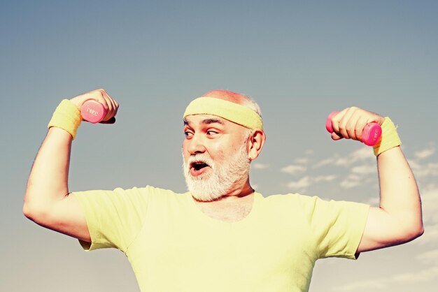 Foto ritratto di uomo anziano azienda manubri come sport ritratto di sano sorriso felice senior grandfath