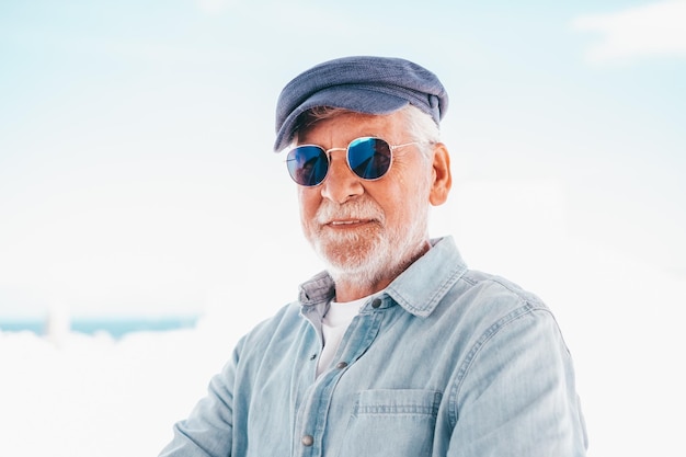 Portrait of senior man looking at camera Face of a handsome old man wearing blue sunglasses and cap