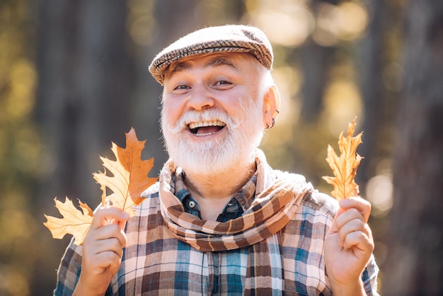 Portrait of a senior man outdoors walking in a park autumn and active holidays old man alone in autu...