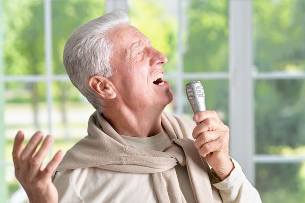 Portrait of a senior man singing into microphone
