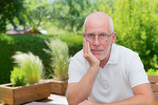 Ritratto dell'uomo senior che sorride nel giardino