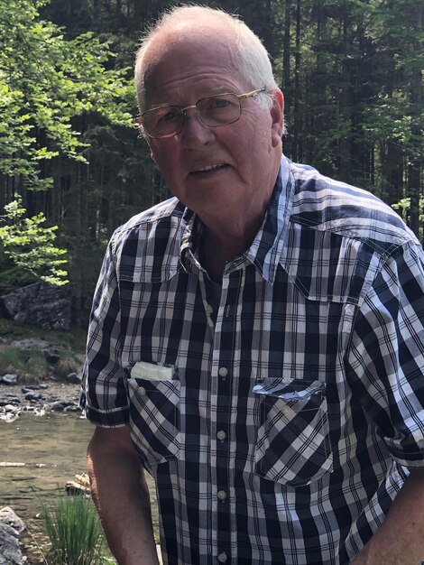 Photo portrait of senior man standing in forest