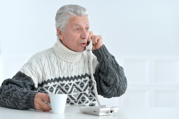 Portrait of senior man talking on phone sitting