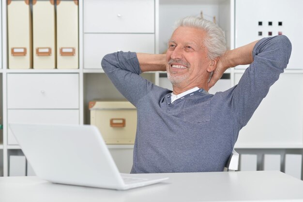 Portrait of senior man using laptop at home