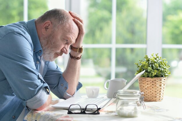 Portrait of a senior man using laptop