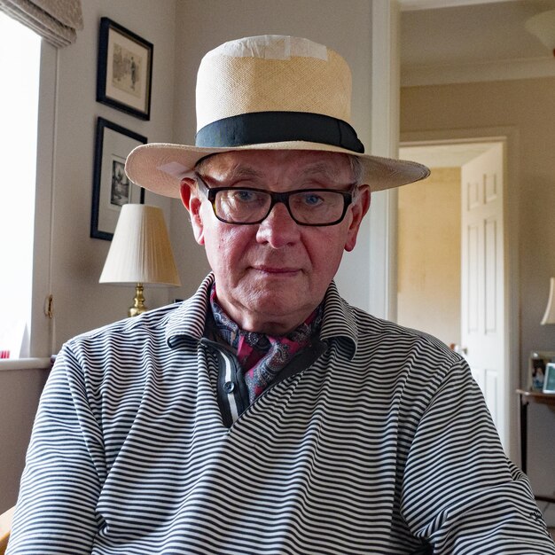Photo portrait of senior man wearing hat at home
