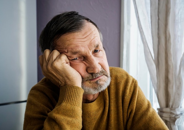 Photo portrait of senior man wearing sweater while sitting at home