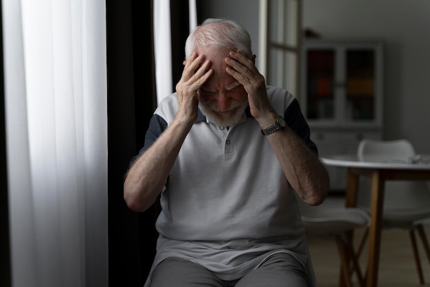 Photo portrait of senior man with alzeihmer indoors